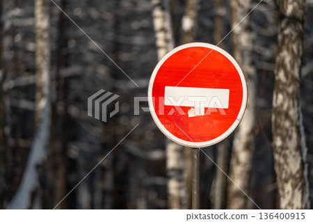 Metal sign amidst winter birch, Closeup of caution sign with snowy birch background, Close perspective on warning sign framed by snowcovered birch trees in winter setting 136400915