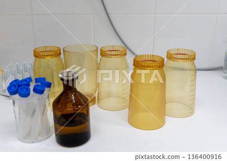 Plastic laboratory funnels and sample containers for water filtration testing on workbench 136400916