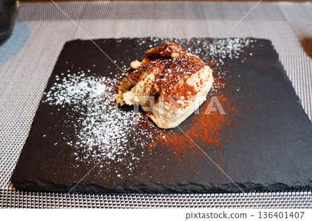 提拉米蘇甜點盛放在黑色盤子裡 提拉米蘇甜點盛放在黑色盤子裡 136401407