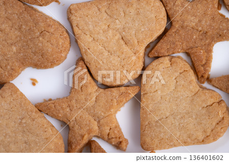Golden brown cookies with mixed shapes for gifting and festivities, Assorted cookies with crisp edges and appealing colors perfect for holiday gifts and display 136401602