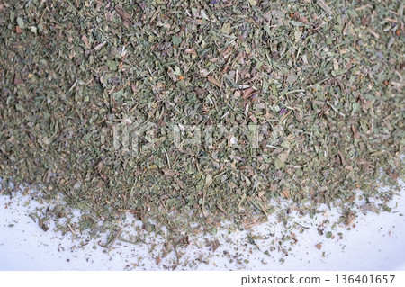 Pile of dried herbs on white, fine green flakes forming textured border, highangle product composition, minimal background for label and food blog, sharp detail for packaging use Pile of dried herbs on white, fine green flakes forming textured border, highangle product composition, minimal background for label and food blog, sharp detail for packaging use 136401657