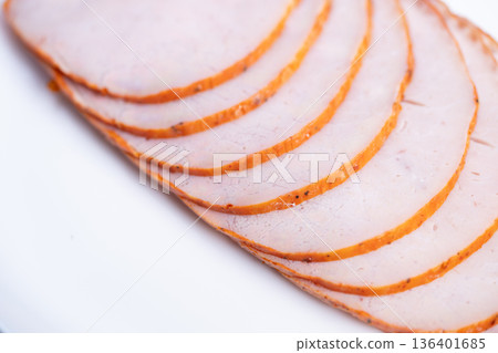 Consistent sliced meat display. Meat segments uniformly sliced for quality assurance. Even thickness meat slices arranged neatly showing manufacturing precision and hygiene 136401685
