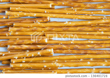 Artisan salted pretzel sticks rustic texture handmade appearance uneven shapes coarse salt crystals golden brown tones premium snack concept for upscale food styling Artisan salted pretzel sticks rustic texture handmade appearance uneven shapes coarse salt crystals golden brown tones premium snack concept for upscale food styling 136401728