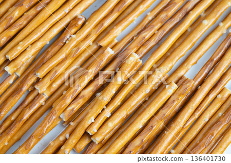 Large saltcoated pretzel sticks organized for sale and display. Extensive arrangement of pretzel sticks with coarse salt designed for online and instore showcases Large saltcoated pretzel sticks organized for sale and display. Extensive arrangement of pretzel sticks with coarse salt designed for online and instore showcases 136401730