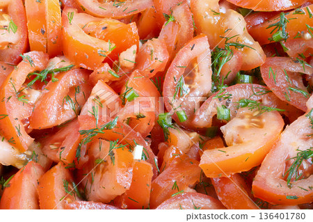 Vibrant tomato salad drizzled with dressing, thin wedges seasoned with dill and garlic, glossy sheen from vinaigrette, closeup texture, menuready plating, cozy bistro mood 136401780