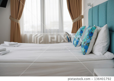 Modern hotel bedroom interior with blue pillows and soft daylight 136401792