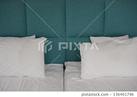 Minimal hotel bed with white pillows and turquoise upholstered headboard Minimal hotel bed with white pillows and turquoise upholstered headboard 136401796