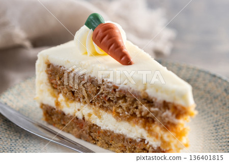 Carrot cake slice with cream cheese frosting on wooden table Carrot cake slice with cream cheese frosting on wooden table 136401815