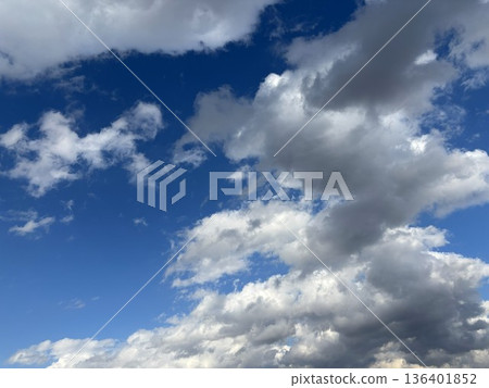 大小不一的白雲漂浮在湛藍的天空。陽光明媚,天氣宜人,自然風光優美。 大小不一的白雲漂浮在湛藍的天空。陽光明媚,天氣宜人,自然風光優美。 136401852