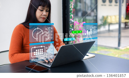 Asian woman using laptop with digital calendar and clock icons, planning schedule and time management concept, professional female working at outdoor cafe. Asian woman using laptop with digital calendar and clock icons, planning schedule and time management concept, professional female working at outdoor cafe. 136401857