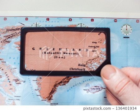 Male hand holds magnifying glass over world map 136401934