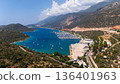 Aerial drone view of Kas marina with yachts and boats in turquoise sea surrounded by mountains and coastline in Turkey. Scenic summer travel destination on Mediterranean coast. 136401963