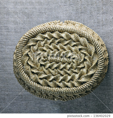 Woven straw basket against a burlap background. Close-up. Details. Eco-friendly. Handmade basket for interior decoration and use as container for collecting fruits, vegetables, and mushrooms. Woven straw basket against a burlap background. Close-up. Details. Eco-friendly. Handmade basket for interior decoration and use as container for collecting fruits, vegetables, and mushrooms. 136402029
