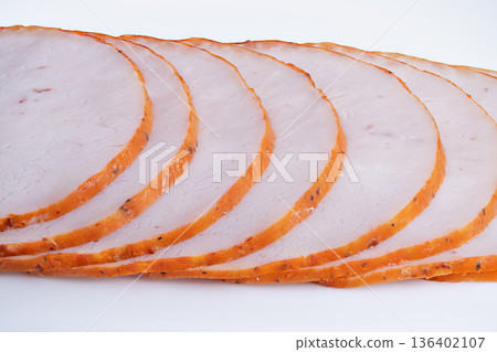 Smoked delicatessen slices. Delicate smoked meat slices perfect for sandwiches and display. Thinly sliced smoked meat ideal for various sandwiches and culinary presentations Smoked delicatessen slices. Delicate smoked meat slices perfect for sandwiches and display. Thinly sliced smoked meat ideal for various sandwiches and culinary presentations 136402107