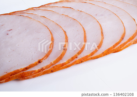 Prepared meat for assorted platters. Thinly sliced meat arranged for displays. Uniformly sliced meat with seasoned edges designed for platters and event presentations 136402108