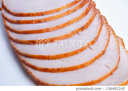 Turkey slices ready for sandwich assembly, thin uniform cuts with seasoned rim, arranged edgewise on white, inspiration for sandwich recipe and foodservice prep Turkey slices ready for sandwich assembly, thin uniform cuts with seasoned rim, arranged edgewise on white, inspiration for sandwich recipe and foodservice prep 136402142