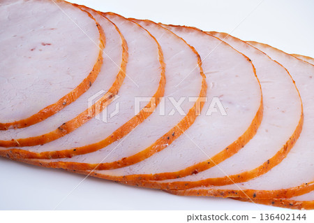 Diagonally arranged moist turkey slices under studio lighting. Thinly sliced smoked turkey breast arranged diagonally with visible spices and moist texture under studio lighting 136402144