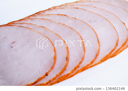Arrangement of sliced cooked meat with packaging idea in mind. Photograph showcasing uniform slices of roasted meat against clean white backdrop for packaging concepts 136402146
