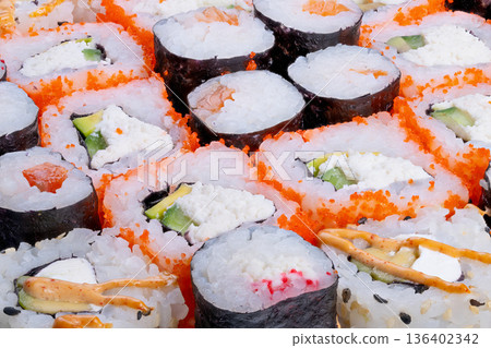 Closeup sushi rolls showcasing chef craft, handrolled texture and precise cuts, premium salmon and avocado, intimate kitchen plating concept for artisanal menus 136402342