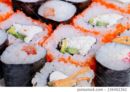 Elegant sushi presentation. Highend sushi arrangement with sophisticated lighting. Closeup view of designer sushi plates crafted for modern sophisticated restaurant menus Elegant sushi presentation. Highend sushi arrangement with sophisticated lighting. Closeup view of designer sushi plates crafted for modern sophisticated restaurant menus 136402362