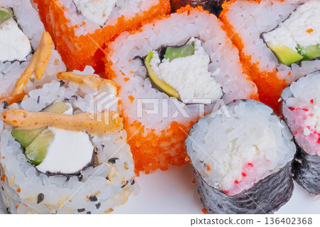 Chefcrafted sushi with garnishes. Studioshot of meticulously prepared sushi rolls. Artfully arranged sushi with detailed cuts and decoration for professional food styling 136402368