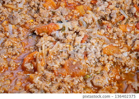 Hearty sauce simmering. Simmering ground meat sauce with vegetables and glossy finish. Comfortable kitchen setting with fragrant meat sauce and hearty pasta preparation 136402375