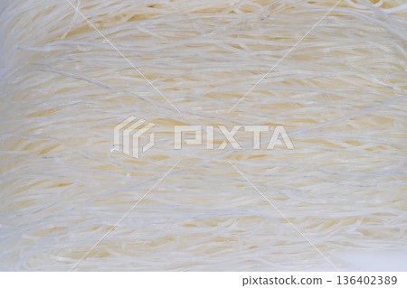 Rustic rice noodle presentation. Natural rice noodles arranged for cooking or serving. Simple rice noodles displayed in rustic pantry evoking warmth and homestyle cooking 136402389