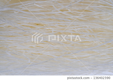 Elegant pattern of stacked clear rice noodles with studio lighting. Macro detail showcasing transparent rice noodles layered beneath neutral background for packaging design Elegant pattern of stacked clear rice noodles with studio lighting. Macro detail showcasing transparent rice noodles layered beneath neutral background for packaging design 136402390