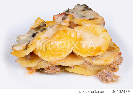 Refined stacked potato disks with smooth topping. Sophisticated small potato gratin portions featuring velvety exterior and elegant presentation suitable for upscale menus 136402429