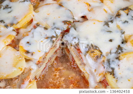 Woodfired artisanal potato pizza with melted cheese and crunchy edges. Handcrafted rustic style potato pizza served on wooden platter with crispy golden edges and melted cheese 136402458