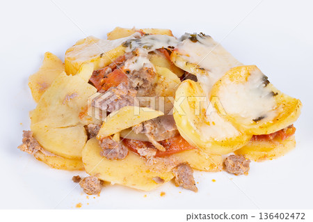 Sliced potato and melted cheese served as latenight snack, scattered meat crumbs and tomato pieces on white dish, greasy shine and soft texture under bright light Sliced potato and melted cheese served as latenight snack, scattered meat crumbs and tomato pieces on white dish, greasy shine and soft texture under bright light 136402472