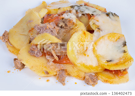 Layered potato rounds topped with sausage, melted mozzarella, warm homestyle casserole feel on plain plate, visible tomato slices and herb sprigs, comforting aroma suggested Layered potato rounds topped with sausage, melted mozzarella, warm homestyle casserole feel on plain plate, visible tomato slices and herb sprigs, comforting aroma suggested 136402473