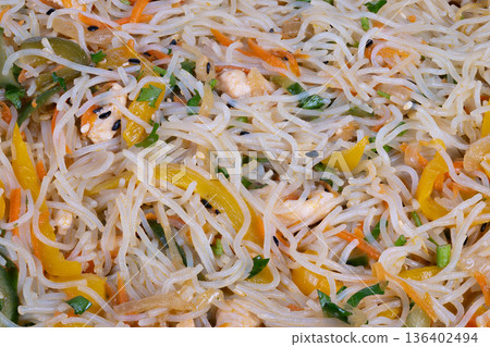 Steaming rice noodles tossed with vegetables and herbs, rustic street vendor energy with smoky notes, quick service container, bright garnishes, hungerinducing closeup Steaming rice noodles tossed with vegetables and herbs, rustic street vendor energy with smoky notes, quick service container, bright garnishes, hungerinducing closeup 136402494