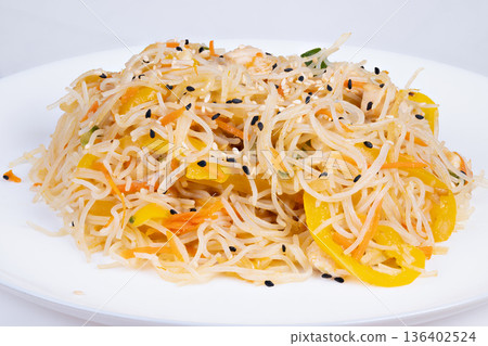 Deconstructed rice vermicelli with yellow pepper, sesame seeds and microherb garnish, delicate balance of savory and fresh notes, elegant restaurant plating under soft spotlight 136402524
