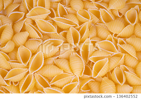 Closeup pasta details. Highresolution macro photograph showing intricate pasta shell ridges. Magnified image capturing detailed surface texture of pasta shell with ridges Closeup pasta details. Highresolution macro photograph showing intricate pasta shell ridges. Magnified image capturing detailed surface texture of pasta shell with ridges 136402552