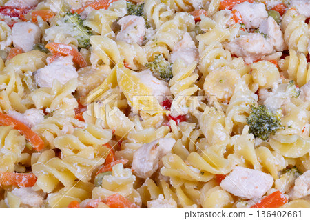 Stylized food photograph showcasing creamy chicken pasta with parmesan. Brightly lit flatlay of savory pasta featuring chicken and cheese garnish ready for sharing 136402681