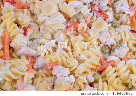 Decorative catering presentation of rich chicken vegetable fusilli with parmesan. Refined buffet display featuring chicken and vegetable fusilli garnished with Parmesan cheese 136402692