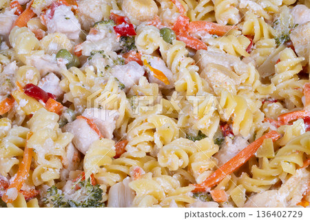 Creamy pasta salad. Colorful vegetable pasta dish. Chilled creamy pasta salad with vibrant vegetables. Large serving of cold creamy pasta with fresh vegetables and dressing 136402729
