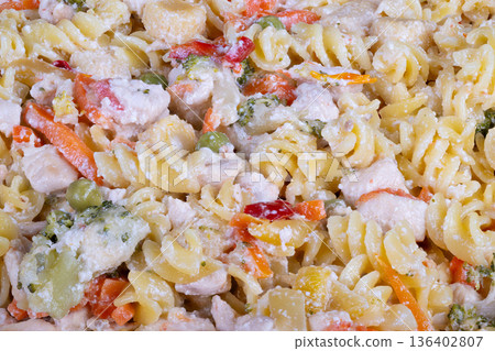Vivid pasta dish captured overhead. Brightly colored pasta garnished with fresh vegetables. Overhead shot showing lively pasta with seasonal vegetable decorations Vivid pasta dish captured overhead. Brightly colored pasta garnished with fresh vegetables. Overhead shot showing lively pasta with seasonal vegetable decorations 136402807