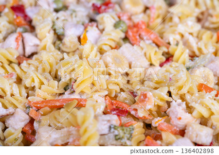 Creamy fusilli noodles mixed with vegetables and tender chicken pieces. Wholesome dish of spiral pasta combined with chopped vegetables and flavorful chicken in creamy dressing Creamy fusilli noodles mixed with vegetables and tender chicken pieces. Wholesome dish of spiral pasta combined with chopped vegetables and flavorful chicken in creamy dressing 136402898