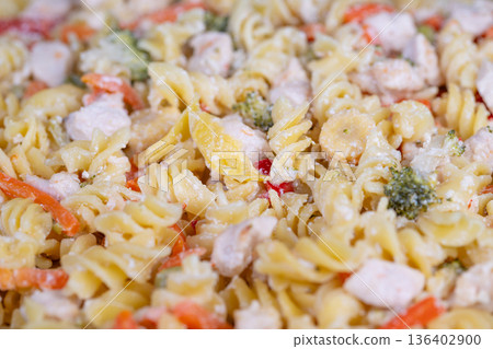 Warm chicken pasta with vegetables. Comforting chicken pasta with peas and peppers. Shared family style chicken pasta filled with colorful vegetables and comforting flavors Warm chicken pasta with vegetables. Comforting chicken pasta with peas and peppers. Shared family style chicken pasta filled with colorful vegetables and comforting flavors 136402900