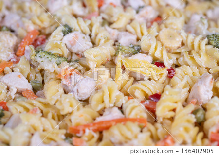 Bright vegetable salad with tender chicken pieces. Vivid pasta salad featuring colorful vegetables and mini chicken chunks perfect for outdoor summer festivities Bright vegetable salad with tender chicken pieces. Vivid pasta salad featuring colorful vegetables and mini chicken chunks perfect for outdoor summer festivities 136402905