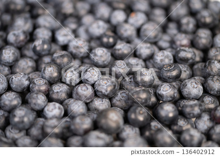 Bright blueberries inspire wellness messages. Energizing image promotes health through vibrant fruits. Lively bowl of berries ignites interest in nutritious healthy living 136402912