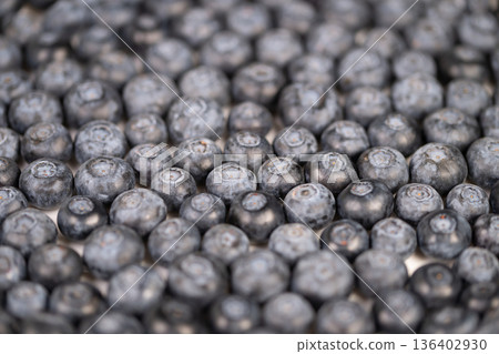 Macro fresh blueberries packed tightly, powdery bloom on skins, muted cool tones, shallow depth of field, tactile pattern ideal for food background and packaging 136402930