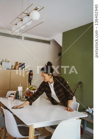 Woman Cleaning Dining Table in Modern Home 136402940