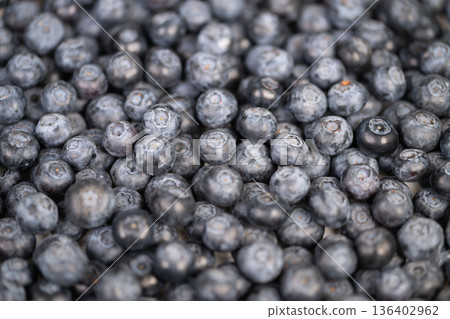 Fresh blueberries staged for smoothie preparation, ingredients laid out for blender, vibrant fruit color and clean composition for plantbased and vegan food marketing 136402962
