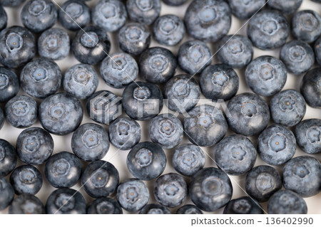Fresh blueberries used as dessert topping, glossy plump fruits arranged for pastry and pastry garnish, mouthwatering colors and tactile appeal for cookbook and culinary branding 136402990