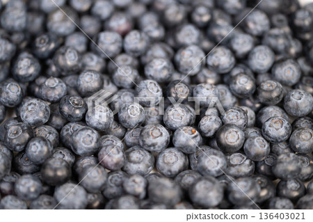 Modern flatlay with blueberries. Fresh blueberries arranged symmetrically for product display. Juicy blueberries evenly spread on clean background for packaging presentation Modern flatlay with blueberries. Fresh blueberries arranged symmetrically for product display. Juicy blueberries evenly spread on clean background for packaging presentation 136403021