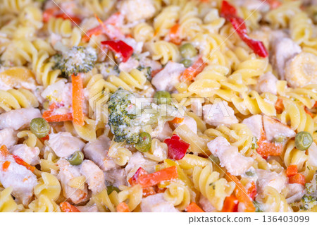 Bright fusilli salad with mixed vegetables, meal prep bowl styled for office lunch, peas, sweet peppers, shredded carrots and corn, chilled dressing, vibrant color 136403099