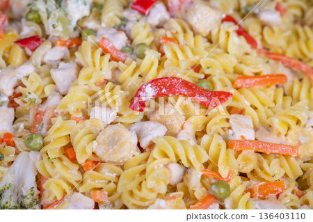 Magnified view of fusilli with colorful vegetable toppings and cheese. Macro shot showcasing fusilli pasta intertwined with vegetables and sprinkled cheese topping Magnified view of fusilli with colorful vegetable toppings and cheese. Macro shot showcasing fusilli pasta intertwined with vegetables and sprinkled cheese topping 136403110